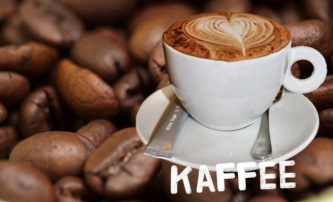 Ein Becher Kaffee auf Kaffeebohnen mit Schriftzug Kaffee