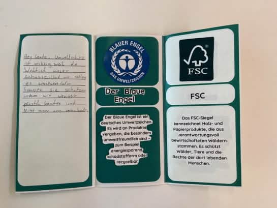 Ein selbst gebastelter Flyer erklärt die Label Blauer Engel und FSC
