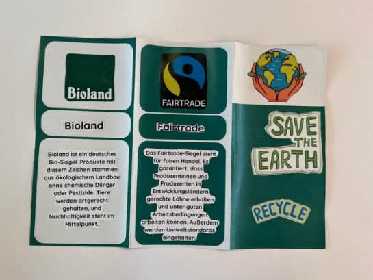 Ein selbst gebastelter Flyer erklärt die Label Bioland und Fairtrade