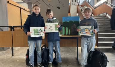 Schüler präsentieren Plakate für die Handy-Sammelaktion