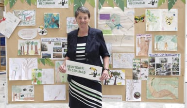 Umweltministerin Hendricks steht vor einer Tafel mit Bildern, Collagen und Texten