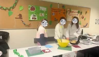 Drei Kinder stehen an einem Tisch und backen Waffeln.