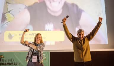 Kathrin Grau, Michel Abdollahi und Willi Weitzel heben die Arme triumpfierend in die Höhe