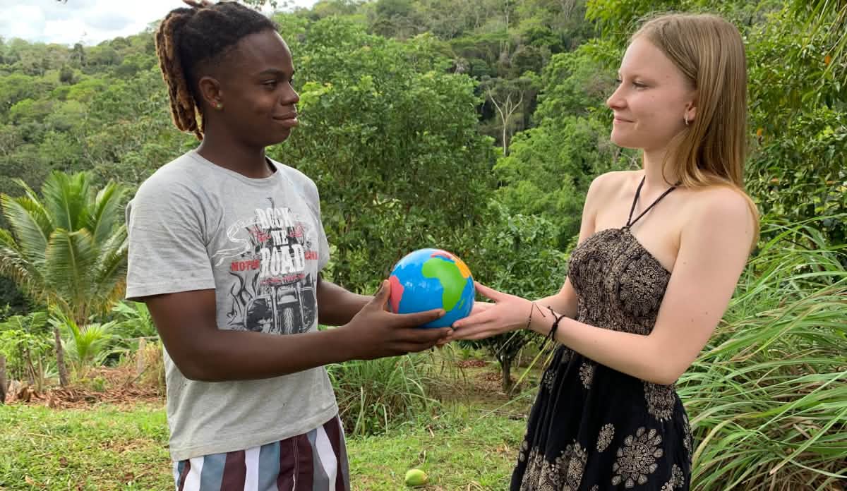 Die ganze Welt gehört zusammen, egal aus welchem Land wir kommen, welche Hautfarbe wir haben und welche Sprache wir sprechen. Das soll dieses Foto mit der Weltkugel symbolisieren. Es entstand – zusammen mit Caíque – ganz am Anfang meines Besuchs, als ich noch kein Portugiesisch sprach. Ein dunkelhäutiger Junge und ein europäisches Mädchen halten eine kleine Weltkugel in den Händen und schauen sich an. Sie stehen vor einem Regenwald