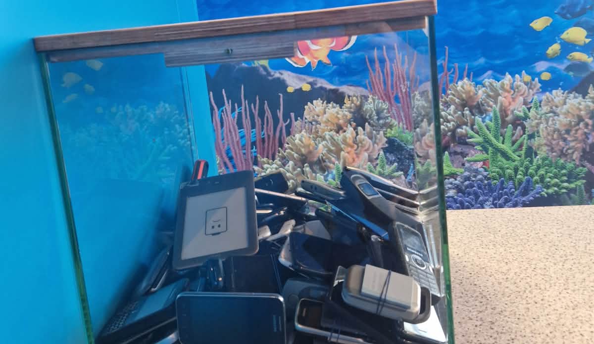 ein Aquarium ist gefüllt mit alten Smartphones