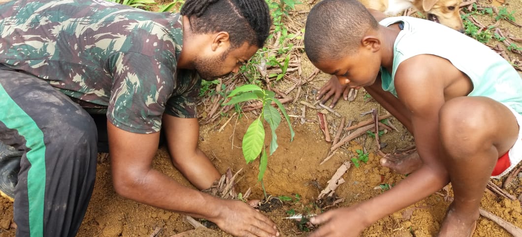 Hebert Silva Santos pflanzt mit Carlos einen junge Setzling, Ort: Fazenda Saúva im Atlantischen Küstenregenwald, Brasilien