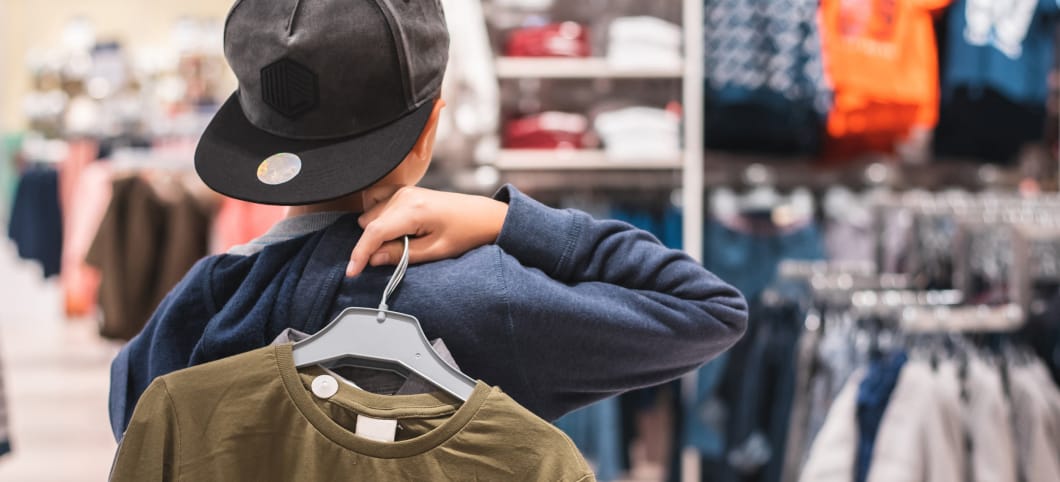 Frankreich will Billigmode mit einem Gesetz bekämpfen Ein Teenager hält ein T-Shirt in einem Klamottenladen