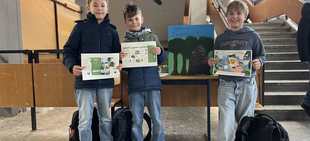 Schüler präsentieren Plakate für die Handy-Sammelaktion