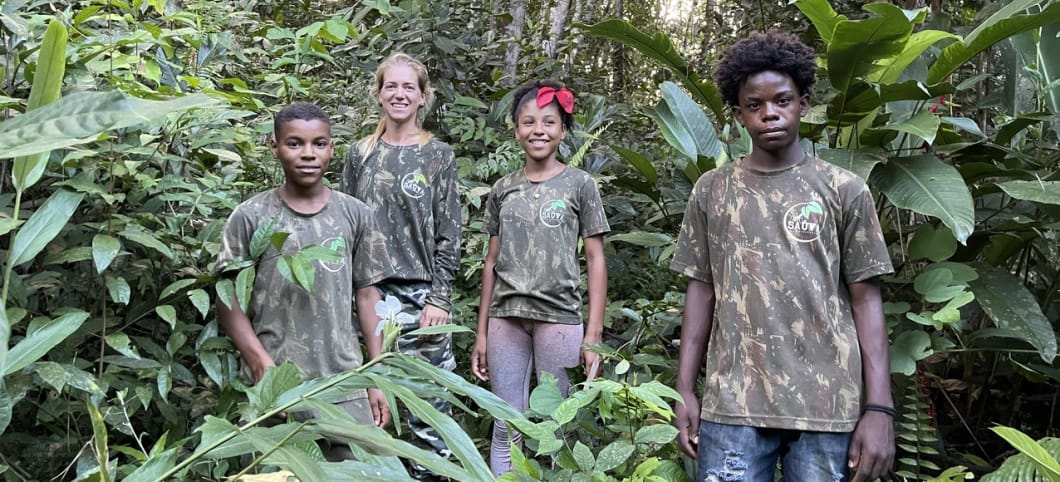 Bianca steht mit drei Kindern im dichten Dschungel