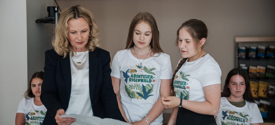 Zwi Kinder übergeben Steffi Lemke ihr gemaltes Regenwald-Bild