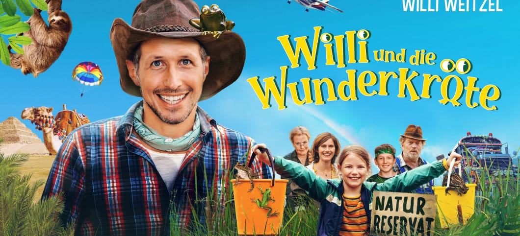 Gewinnt Freikarten für den neuen Kinofilm mit Willi Weitzel Filmplakat auf dem Willi Weitzel mit Frosch auf dem Hut neben anderen Mitspielern aus dem Film steht