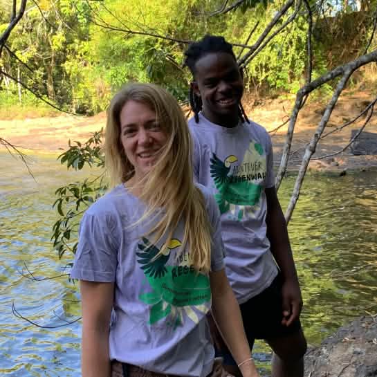 Bianca und Caique stehen am Flussufer im Regenwald